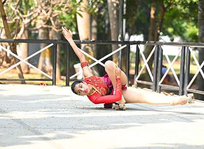 Rhythm Mamania showcasing flexibility in a floor pose during a roller skating performance